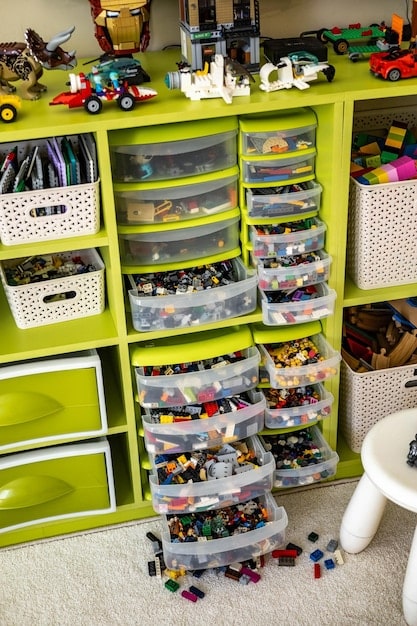 Organized storage bins filled with different types of toys, neatly arranged in a closet. The scene showcases an effective toy rotation system with labeled bins for easy access and organization.