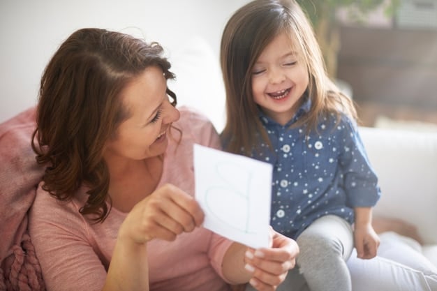 A mother helping her child identify emotions using flashcards with different facial expressions. Both are engaged and smiling.