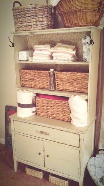 A well-organized command center in a mudroom, featuring labeled baskets for each family member, a calendar with color-coded appointments, and a whiteboard with the week's meal plan. Natural light streams through a nearby window, highlighting the clean and functional design.