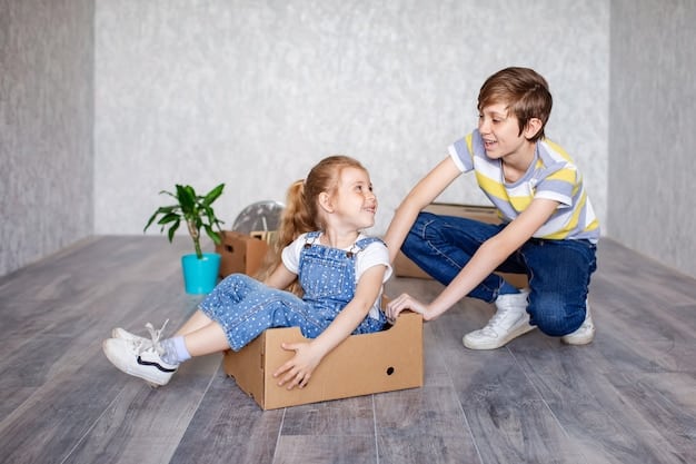 Two children sitting on the floor, surrounded by household items and cardboard boxes. One child is wearing a cardboard box as a helmet, while the other is painting a cardboard castle. The scene is filled with creativity and imagination.