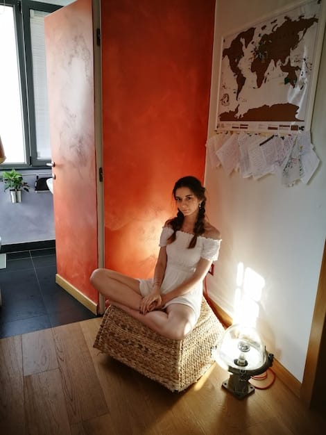 A serene mom meditating in a quiet corner of her home, with soft lighting and calming colors enhancing the scene.