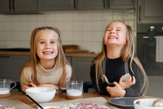 A mother and her two children are sitting at a kitchen table, laughing and covered in flour. They are making cookies together, with bowls of ingredients and baking supplies scattered around them. The scene captures a joyful and chaotic baking session.