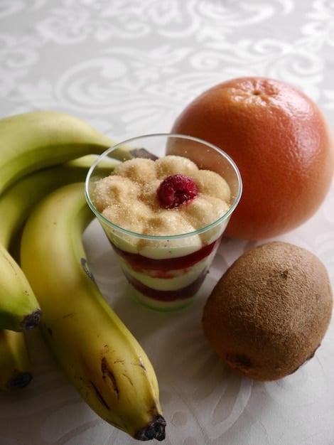 A close-up shot of a variety of colorful, single-ingredient purees in small glass bowls, such as sweet potato, avocado, and banana. The purees are smooth and appetizing.