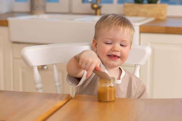 A baby sitting in a high chair, happily reaching for a spoon with peanut butter. The parent is close by, smiling and encouraging the baby. The focus is on the baby's positive reaction and the safe, supportive environment.