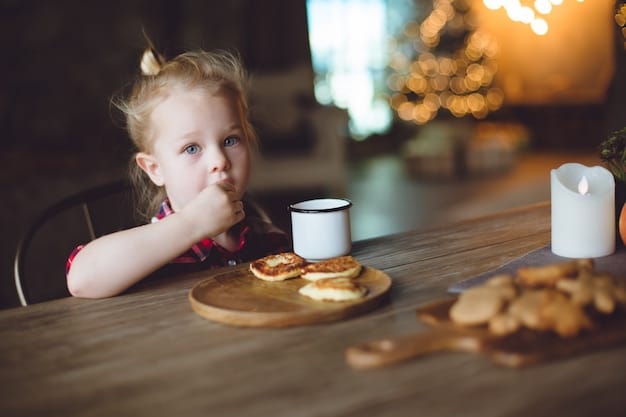A toddler sitting at a small table, happily feeding themselves bite-sized pieces of chicken and steamed vegetables from a colorful plate. The background shows a bright and family-friendly kitchen setting with various healthy food ingredients visible.