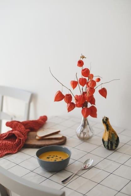 A minimalist dining space with soft lighting. A mother is mindfully setting the table with a colorful placemat, a single flower in a vase, and a balanced plate of food.