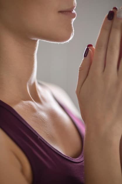 A close-up shot of a woman's hands in a meditative pose (mudra) on her lap, with soft focus on the background, conveying tranquility and mindfulness.