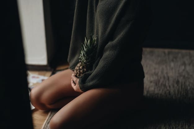 A close-up shot of a woman's hands gently resting on her knees while meditating, with soft light illuminating her face. The backdrop is a blurred, warm-toned room with plants, creating a serene atmosphere.