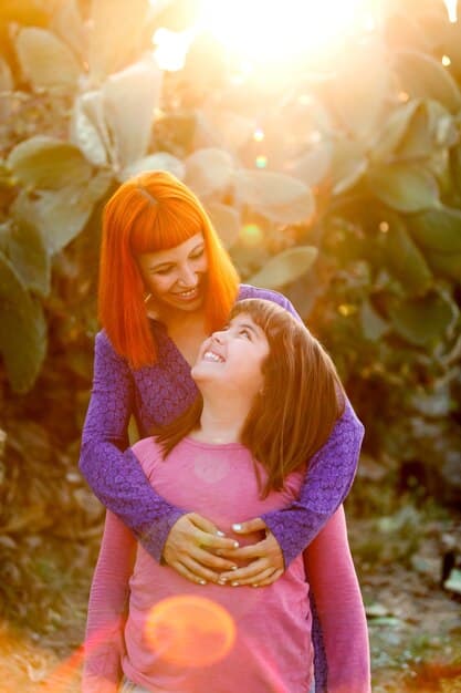 A mother hugging her child tightly, both smiling, illustrating the feeling of gratitude for family and connection.