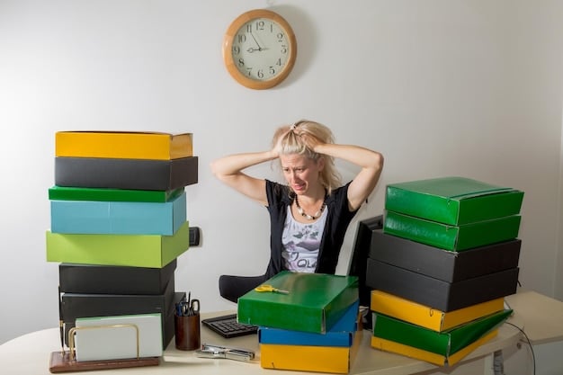 A tired, stressed woman closes her eyes and covers her face with her hands in an office. Her desk is cluttered with several unorganized documents and office supplies.
