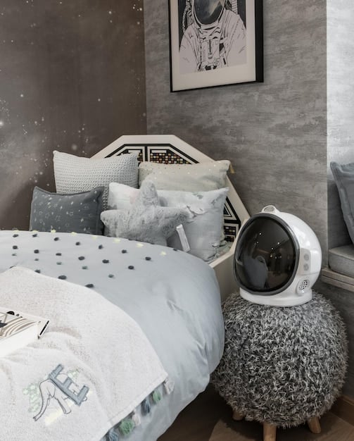 A cozy and inviting bedroom designed for a child, featuring blackout curtains, a comfortable bed with age-appropriate bedding, and a white noise machine on the nightstand.