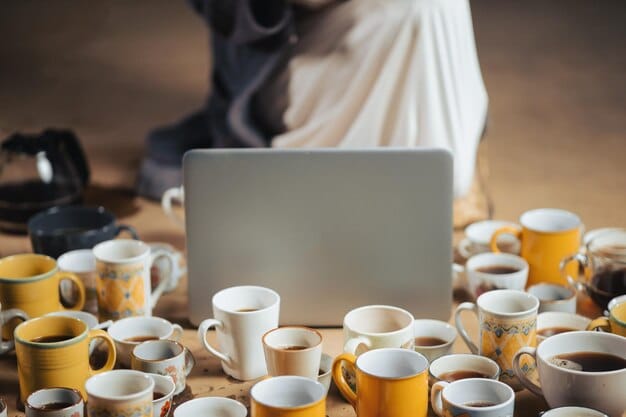 A person staring blankly at a computer screen, with multiple coffee cups scattered around, hinting at exhaustion and a struggle to focus. The image is desaturated to emphasize the feeling of depletion.