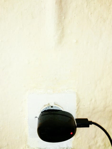 A close-up shot of a power outlet with a sound machine plugged in, highlighting the energy consumption aspect.