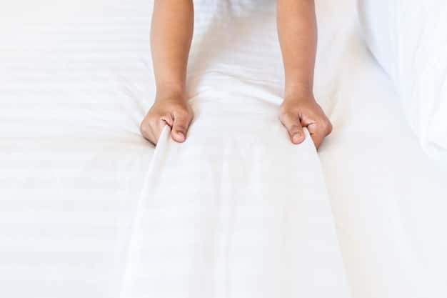 A close-up shot of a hand pressing firmly on a crib mattress, clearly demonstrating the mattress's firmness and how quickly it rebounds. The focus is on the texture and resilience of the mattress material.